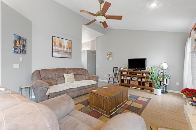 living area featuring baseboards, lofted ceiling, light wood-style floors, and ceiling fan