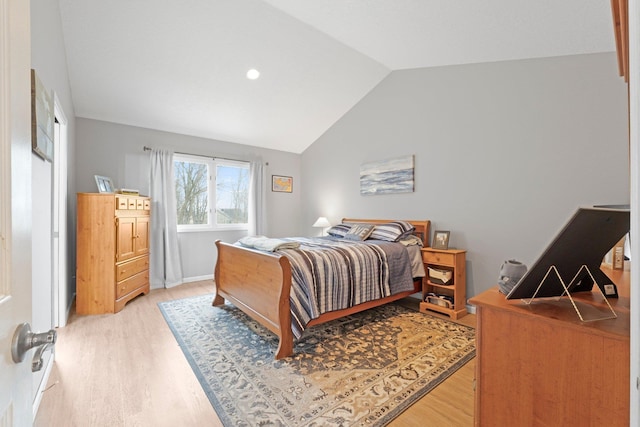 bedroom with vaulted ceiling and light wood-type flooring