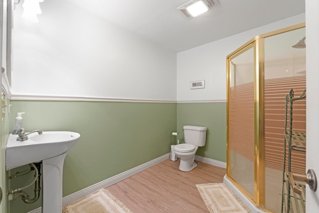 full bathroom with toilet, a shower stall, wood finished floors, baseboards, and visible vents