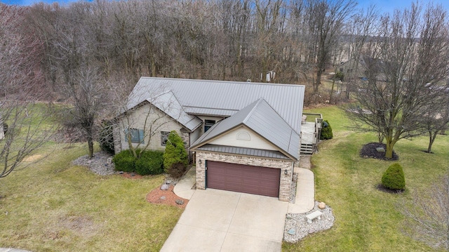 view of front of home featuring driveway, stone siding, metal roof, and a front lawn