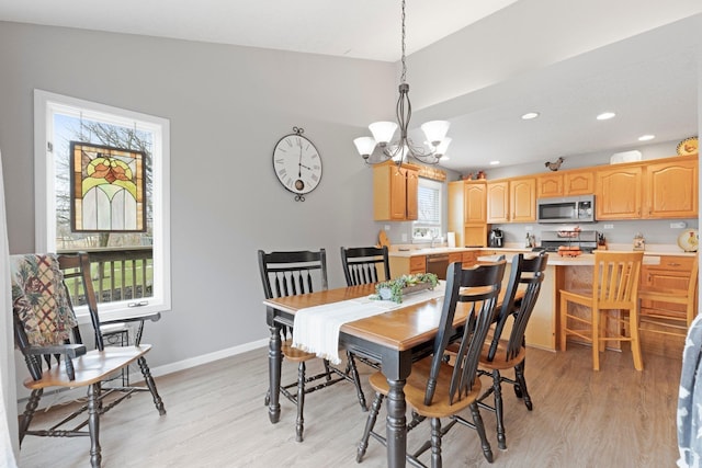 dining space featuring baseboards, lofted ceiling, light wood-style flooring, and a notable chandelier