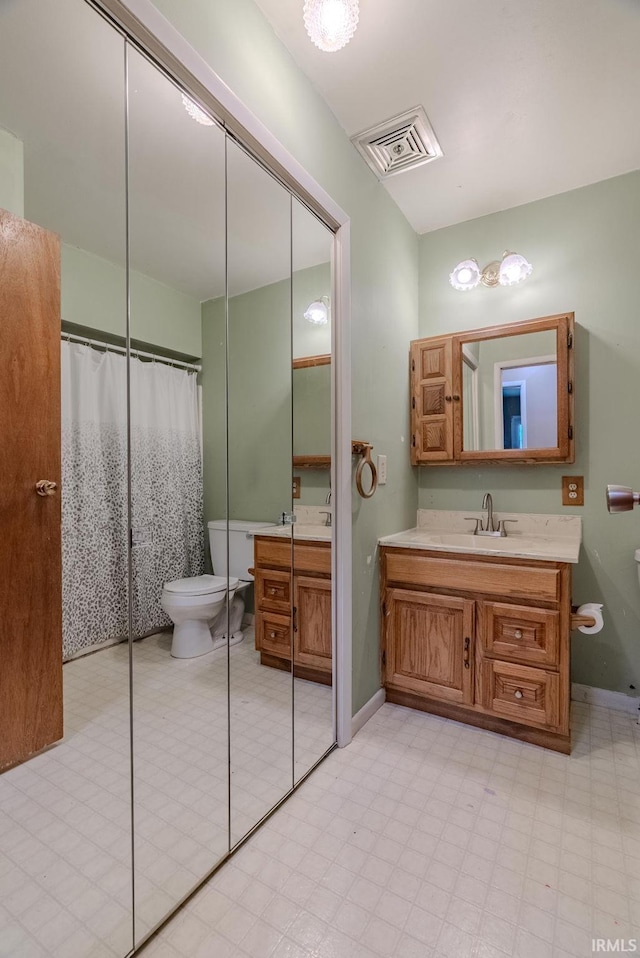 bathroom featuring tile patterned floors, toilet, vanity, baseboards, and visible vents
