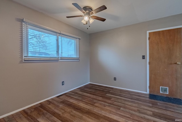 unfurnished room with baseboards, wood finished floors, and ceiling fan