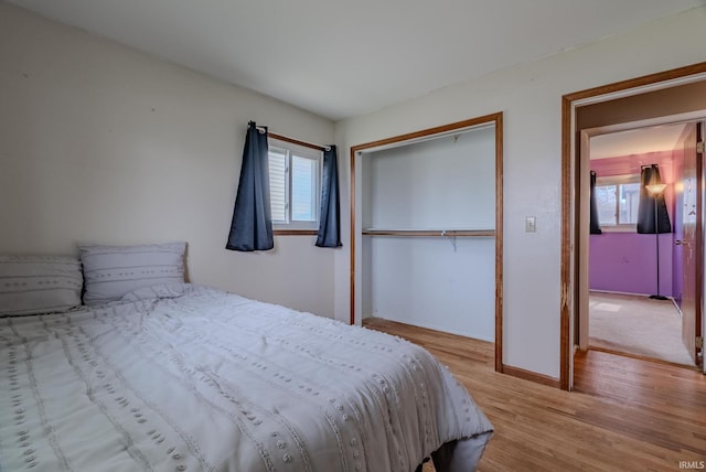 unfurnished bedroom featuring baseboards, a closet, and wood finished floors