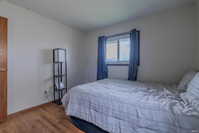bedroom featuring baseboards and wood finished floors