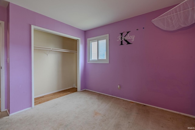 unfurnished bedroom featuring carpet flooring, baseboards, and a closet