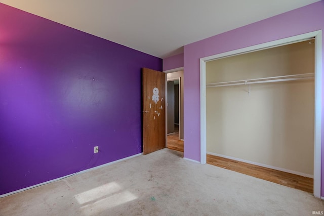 unfurnished bedroom featuring carpet, a closet, and baseboards