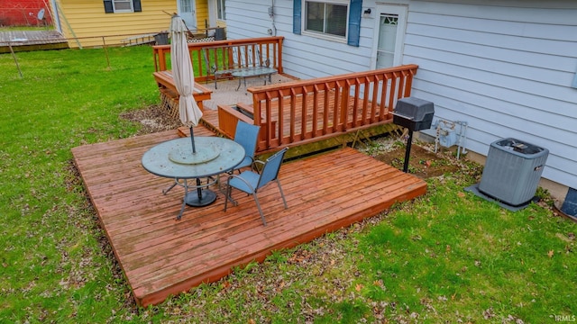wooden terrace featuring central AC unit and a yard