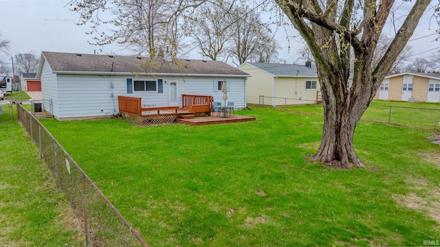 back of house with a fenced backyard, a deck, and a yard