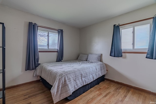 bedroom with baseboards and wood finished floors