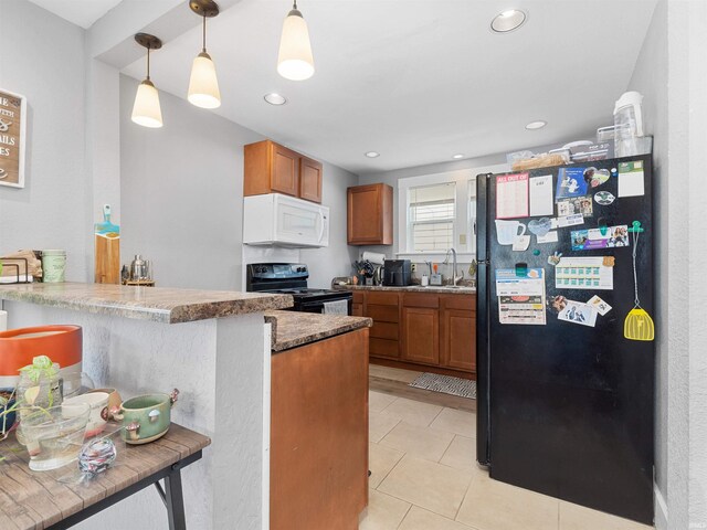 kitchen featuring decorative light fixtures, black appliances, a sink, and brown cabinetry