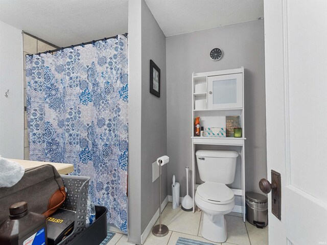 full bathroom featuring a textured ceiling, a shower with shower curtain, baseboards, toilet, and tile patterned flooring