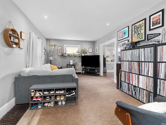 carpeted living area with baseboards and recessed lighting