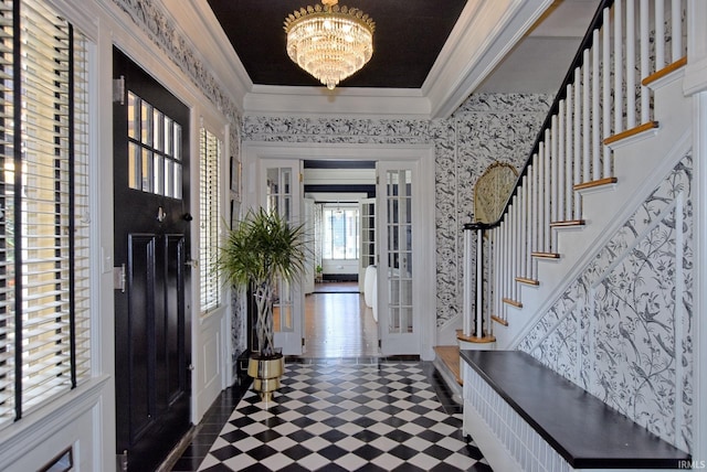 entryway with french doors, ornamental molding, an inviting chandelier, stairway, and dark floors