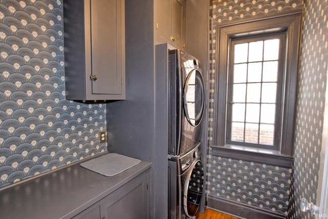 laundry area with cabinet space and stacked washing maching and dryer