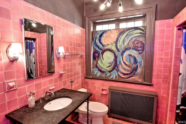 bathroom featuring a sink, tile walls, toilet, and radiator heating unit