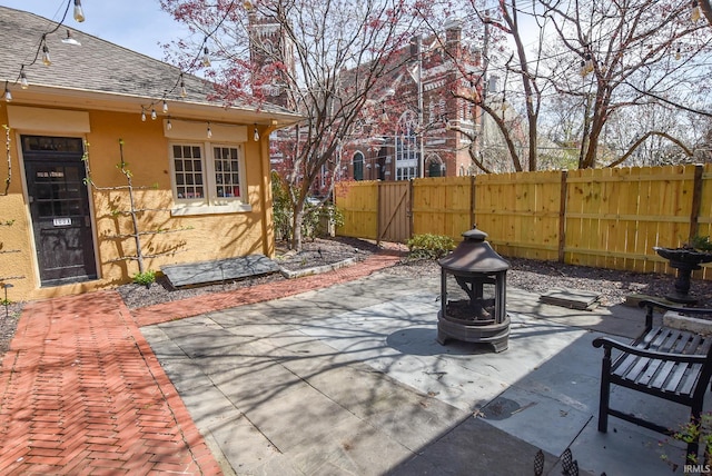 view of patio with a fire pit, a gate, and fence