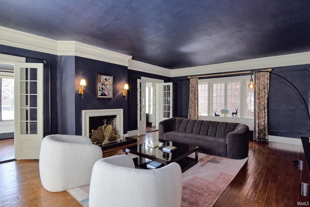 living room featuring ornamental molding, baseboards, and wood-type flooring