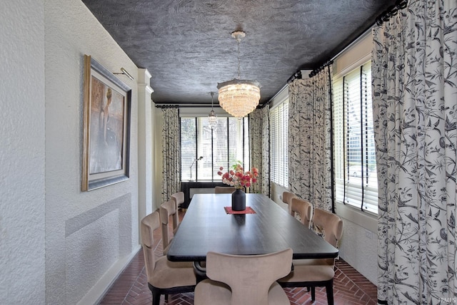 dining room with brick floor, a textured ceiling, a textured wall, and a notable chandelier
