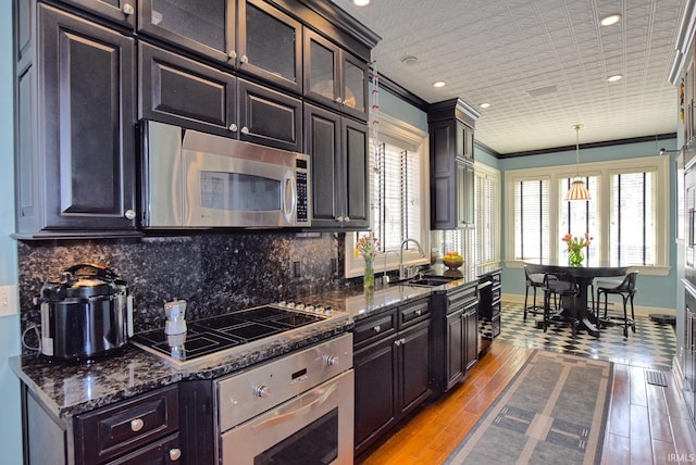 kitchen featuring a sink, stainless steel appliances, tasteful backsplash, and baseboards