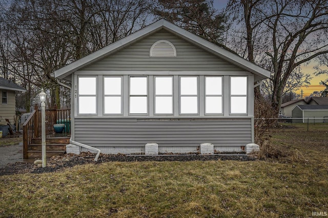 view of side of property with crawl space, fence, and a yard