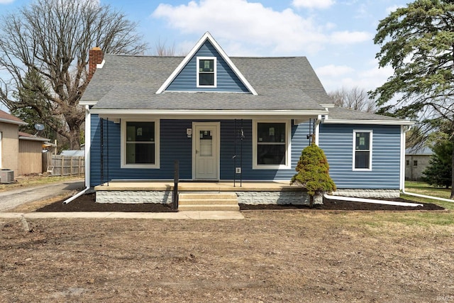 bungalow featuring a shingled roof, a porch, fence, and a chimney