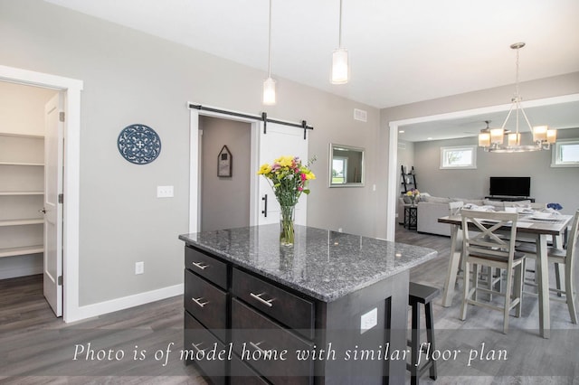 54691 Pierre Trails Dr, Osceola, IN 46561 - kitchen featuring dark wood-style flooring, a barn door, a kitchen island, a chandelier, and baseboards