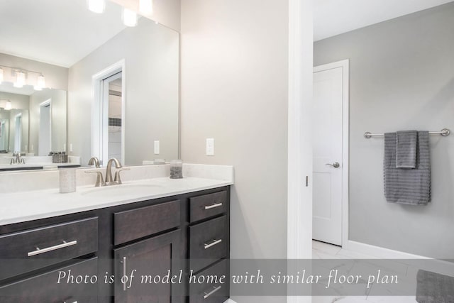 bathroom with vanity, marble finish floor, and baseboards