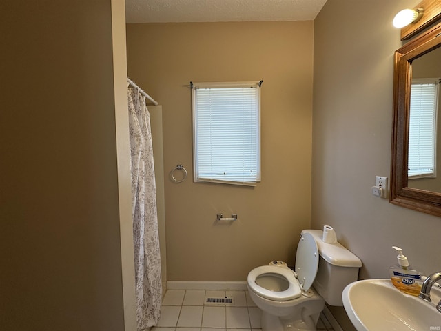 bathroom featuring tile patterned floors, a sink, curtained shower, toilet, and visible vents
