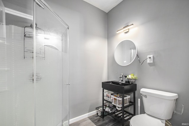 full bath with a shower, toilet, baseboards, a sink, and wood finished floors