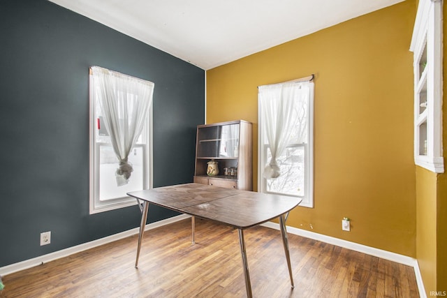 unfurnished office featuring baseboards and wood finished floors