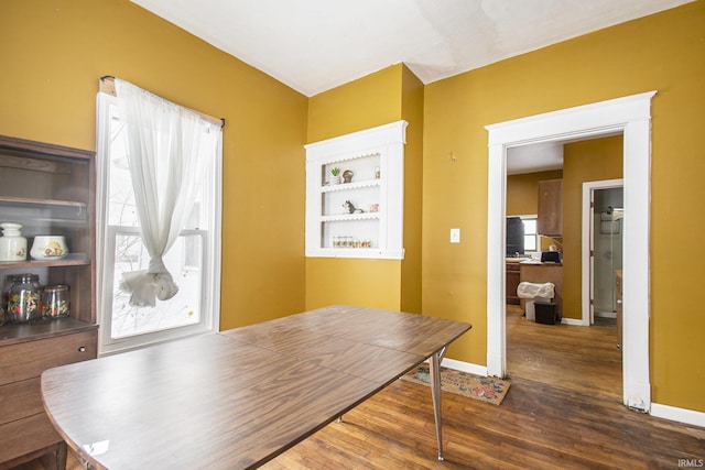dining area with dark wood finished floors and baseboards