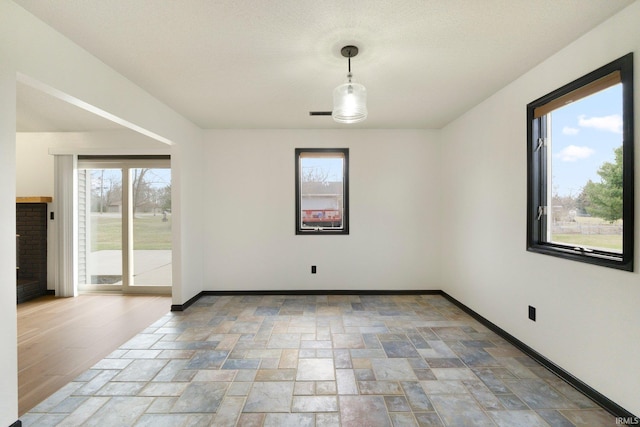 empty room with baseboards and stone finish flooring