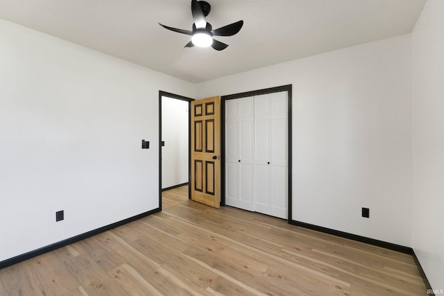 unfurnished bedroom featuring baseboards, a closet, light wood-style floors, and ceiling fan