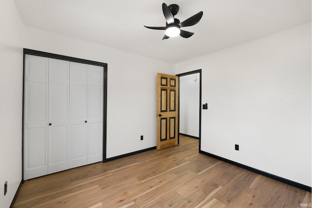 unfurnished bedroom with baseboards, a closet, light wood-style floors, and ceiling fan