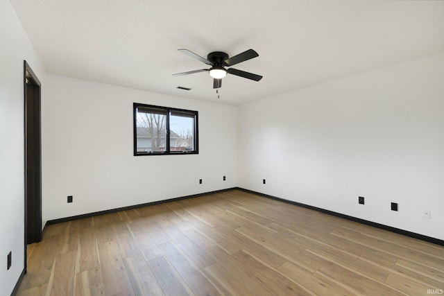 spare room featuring baseboards, visible vents, ceiling fan, and light wood-style flooring