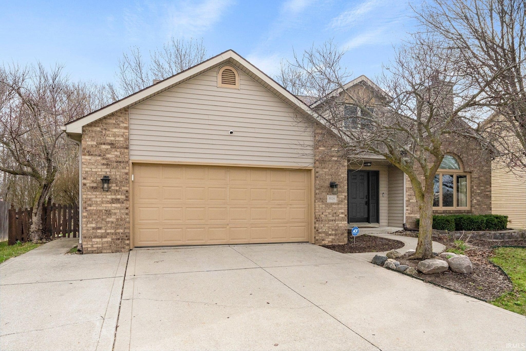 view of front of house featuring driveway, an attached garage, and brick siding