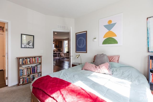 carpeted bedroom featuring visible vents