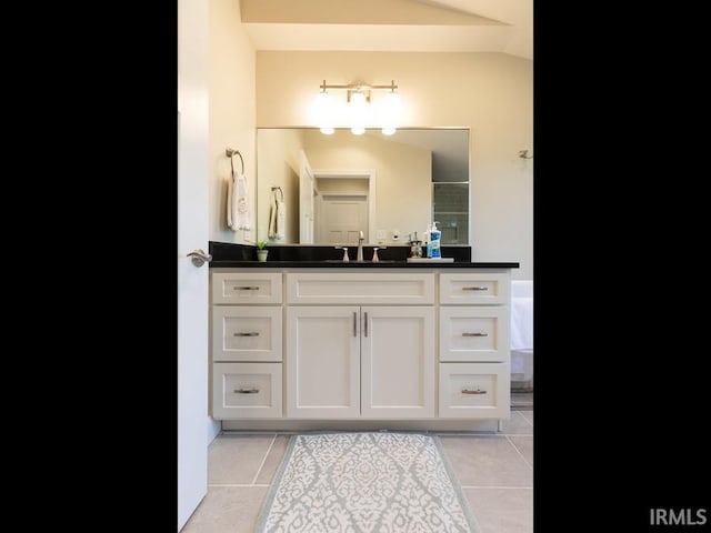 bathroom featuring tile patterned floors, vanity, and vaulted ceiling