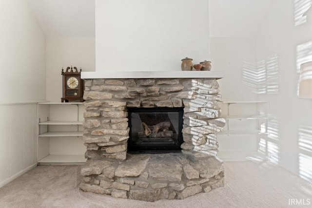 room details featuring a wainscoted wall, carpet, and a fireplace