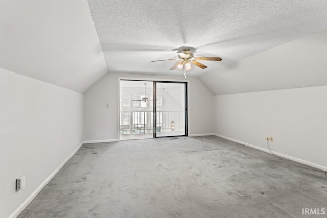bonus room featuring vaulted ceiling, carpet floors, a ceiling fan, a textured ceiling, and baseboards