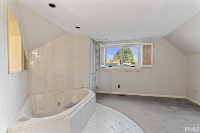 bathroom featuring baseboards, vaulted ceiling, and a jetted tub