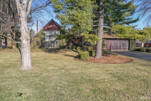 view of front of house with driveway, a garage, and a front yard