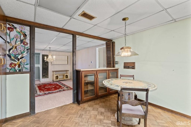 dining room featuring a paneled ceiling, a notable chandelier, baseboards, and visible vents