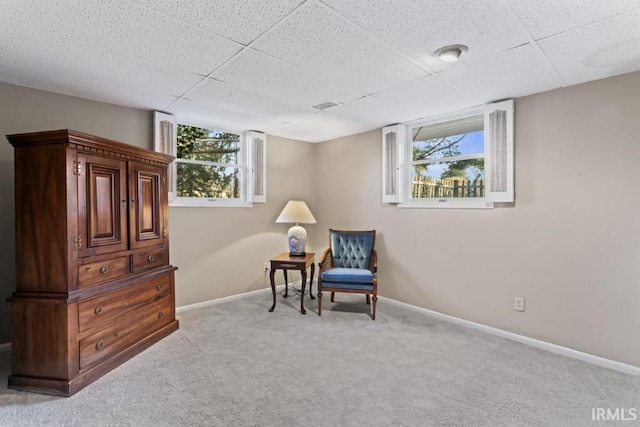 living area featuring baseboards, visible vents, carpet, and a drop ceiling