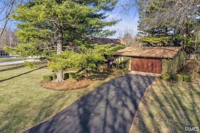 view of front facade with a front yard and a detached garage