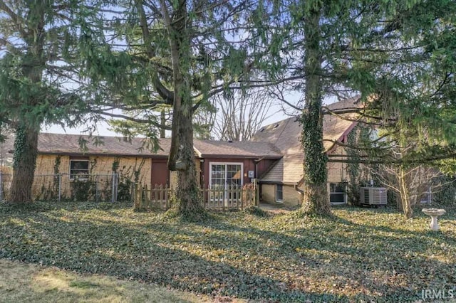 rear view of property with fence and brick siding