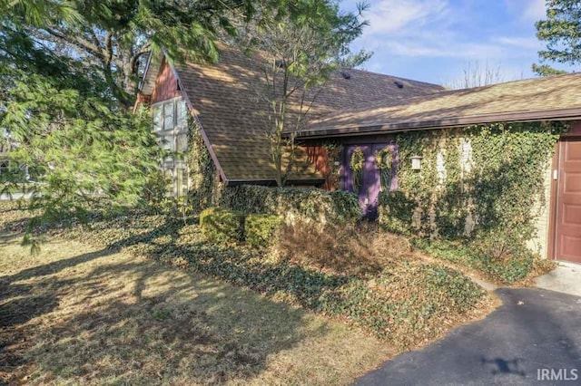 view of property exterior featuring a shingled roof