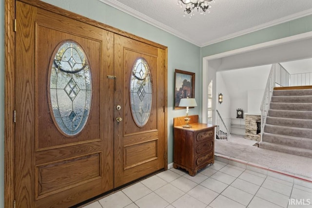 foyer entrance featuring a textured ceiling, ornamental molding, light tile patterned floors, and a healthy amount of sunlight