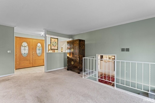 carpeted empty room with baseboards, visible vents, and ornamental molding